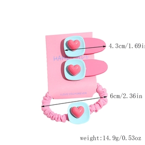 Vue détaillée de l'ensemble de barrettes à cheveux coeur rose et chouchou assorti