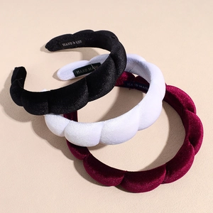 Detailed view of handmade velvet padded headbands in black, white, and burgundy colors
