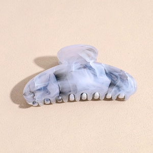 Detailed top view of a marbled acrylic hair claw clip with grey and white patterns