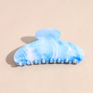 Detail of blue and white marble pattern hair claw clip with sturdy spring mechanism
