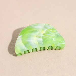 Macro detail of the green marble pattern and smooth texture on this large acrylic hair claw