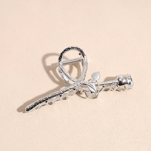 Detailed close-up of a silver metal rose hair claw clip with artistic floral thorns
