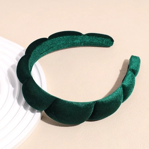 Close-up detail of dark green velvet sponge headband with thick padded quilted texture