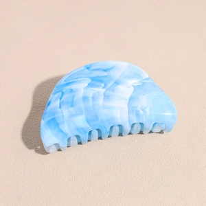 Detailed view of the blue marble texture and glossy finish on the acrylic hair claw clip