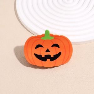 Close-up of matte orange pumpkin hair claw with classic black jack-o'-lantern face detail