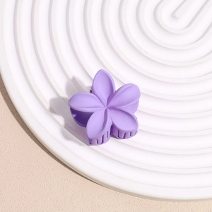 Vue détaillée d'une petite pince à cheveux fleur violette mate avec dents robustes