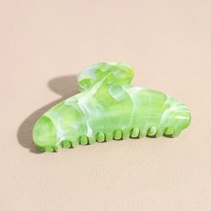 Detail of light green marbled acrylic hair claw clip with smooth polished finish