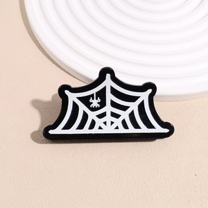 Detail of a black acrylic Halloween hair claw clip featuring a white spider web pattern