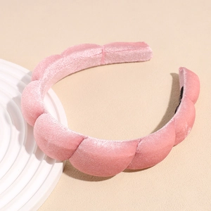 Detailed view of the wavy padded velvet headband in soft lotus pink color