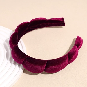 Detail of burgundy velvet padded headband with pleated wave texture on stone base