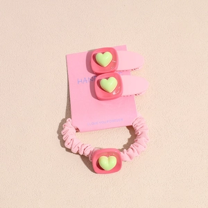 Barrettes cœur rose et chouchou présentés sur une carte en papier fait main
