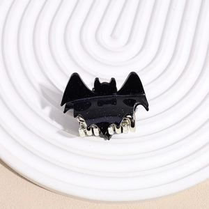 Detail of black glitter bat hair claw clip with silver teeth for Halloween styling