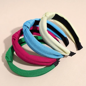 Set of four colorful knotted fabric headbands in yellow, blue, pink and green tones