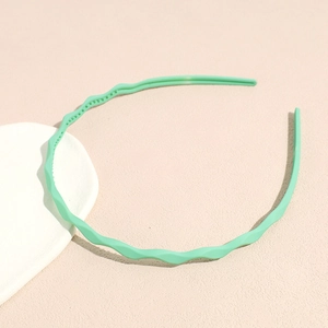 Detail of light green wavy headband showing anti-slip inner teeth and matte texture