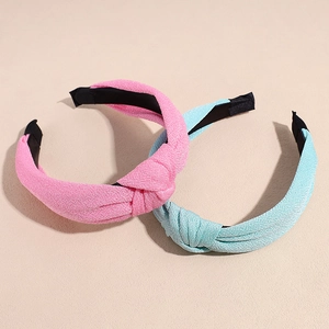 Knotted solid color headbands in pink and light blue with textured fabric finish