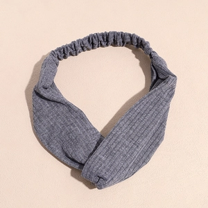 Vue de dessus du bandeau en maille côtelée grise montrant le détail torsadé et la texture