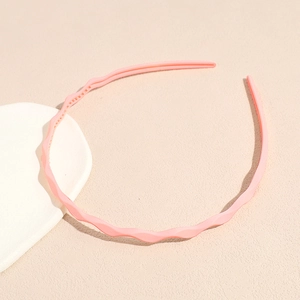 Close-up of pink wavy headband showing non-slip inner teeth and matte texture