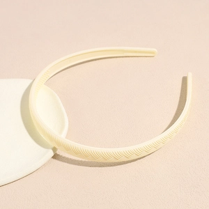 Detail view of cream yellow headband with wheat braid texture and non-slip inner teeth