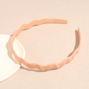 Detail of matte wavy headband showing non-slip inner teeth in peach cream finish