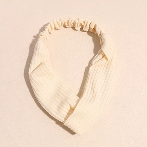 Vue détaillée du bandeau de yoga en tricot beige avec un design élégant de nœud torsadé