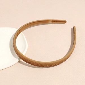 Detail of matte brown hairband with diagonal braided texture and inner non-slip teeth