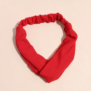 Détail du bandeau rouge en tricot torsadé avec texture côtelée et design élastique