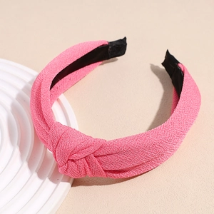 Macro detail of pink knotted headband showing fine fabric texture and black non-slip lining