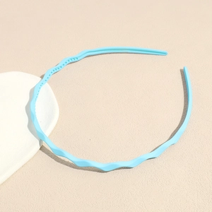Detail view of light blue wavy plastic headband featuring anti-slip inner teeth design