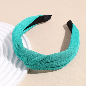 Detail shot of turquoise knotted headband with premium knit texture and non-slip lining