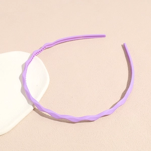 Close-up of a purple wavy headband with non-slip teeth on a white aesthetic tray