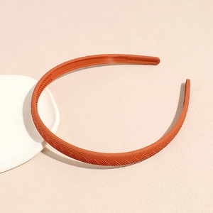 Detail of a thin brick red matte headband featuring woven texture and anti-slip teeth