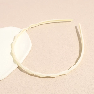 Detail of wavy cream hairband with non-slip inner teeth for secure daily styling