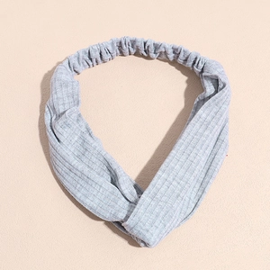 Détail macro d'un bandeau de yoga en tricot gris clair avec un nœud croisé stylé à l'avant