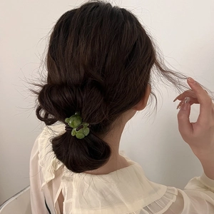Élastique à cheveux ours vert translucide en résine sur un chignon élégant