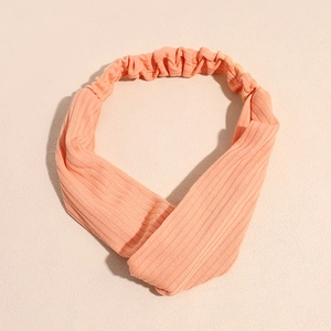 Détail du bandeau de yoga orange en tricot côtelé avec le nœud croisé et la bande élastique