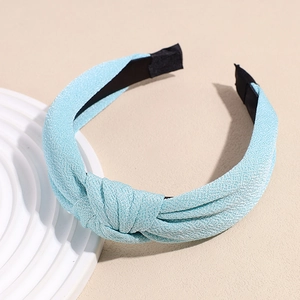 Detail view of light blue knotted fabric headband with soft textured finish and wide design