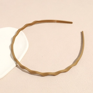 Detail view of khaki wave headband with anti-slip inner teeth on minimalist background