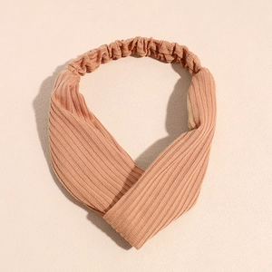 Gros plan sur la texture tricotée et le nœud torsadé du bandeau de yoga orange
