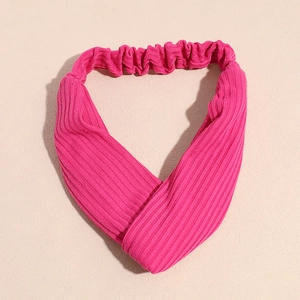 Détail du bandeau en maille côtelée rose avec un design croisé torsadé sur le devant