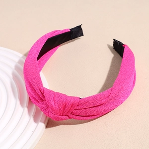 Close-up of pink knotted headband with shimmering fabric texture and protective tips