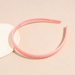 Detail showing the pink frosted headband texture and anti-slip teeth on a neutral surface