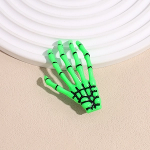 Détail de la pince à cheveux main de squelette vert fluo avec accents de structure osseuse