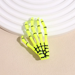 Gros plan sur la pince à cheveux main de squelette jaune fluo montrant les détails