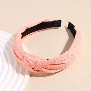 Close-up of pink knotted headband featuring textured fabric and black non-slip lining