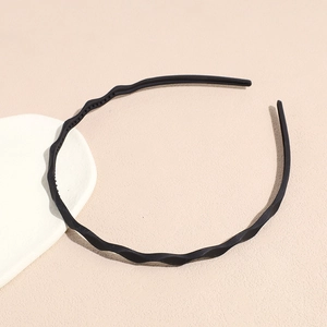 Detail view of matte black wavy headband with anti-slip teeth and slim resin design