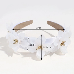 Détail de fleurs 3D blanches et étamines dorées sur le serre-tête large élégant