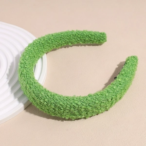 Détail d'un serre-tête vert vif en peluche avec tissu bouclé texturé et design large chic