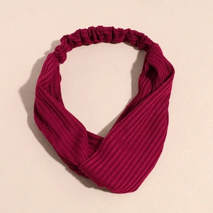 Gros plan du bandeau tricoté bordeaux avec texture côtelée et détail de nœud torsadé