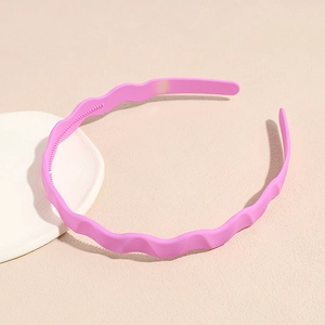 Detail of a bright pink wavy headband with matte finish and non-slip inner teeth