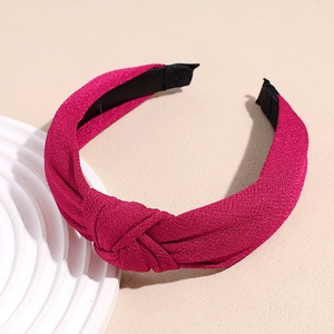 Detail view of rose pink knotted headband with textured fabric and non-slip lining